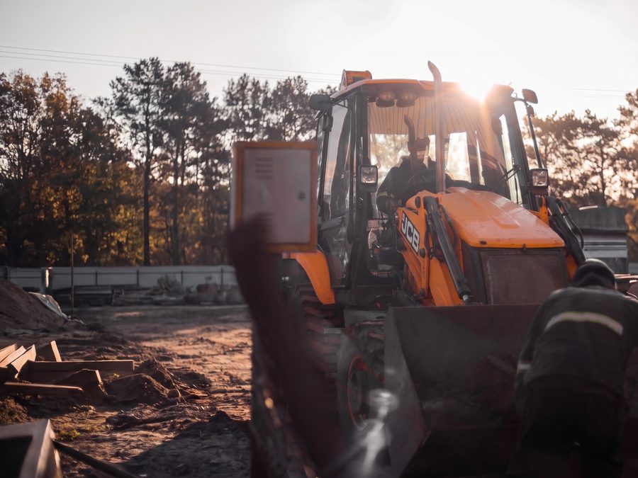 Retroescavadeira JCB da Brava operando em obra ao pôr do sol